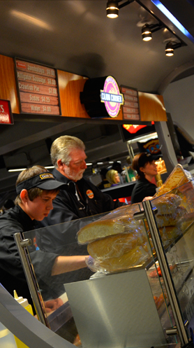 The team slicing fresh poboy bread mid-shift behind the concession counter