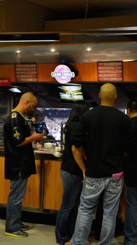 Fans in Saints jerseys placing orders at the Cajun Corner counter